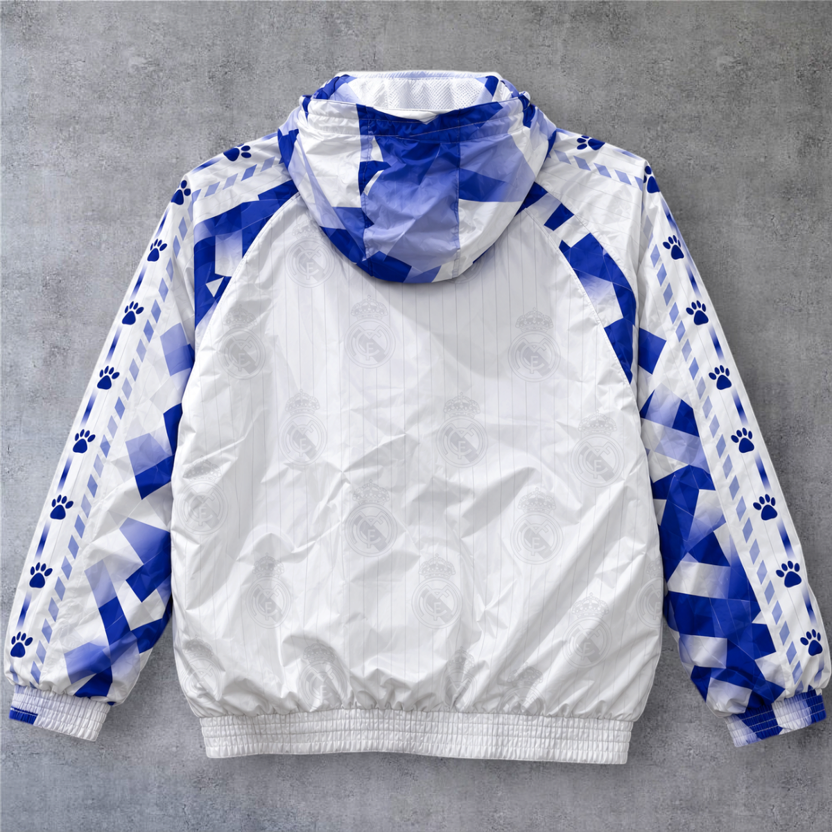 Casaco vintage Real Madrid 1995/96 da A minha loja, branco e azul com capuz, fecho completo e detalhes geométricos.