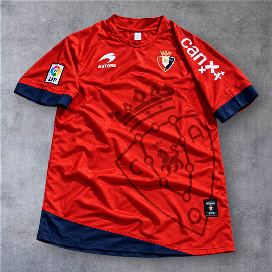 Camisola oficial A minha loja do Osasuna 2010/11, vermelha com detalhes em azul marinho e emblema do clube.