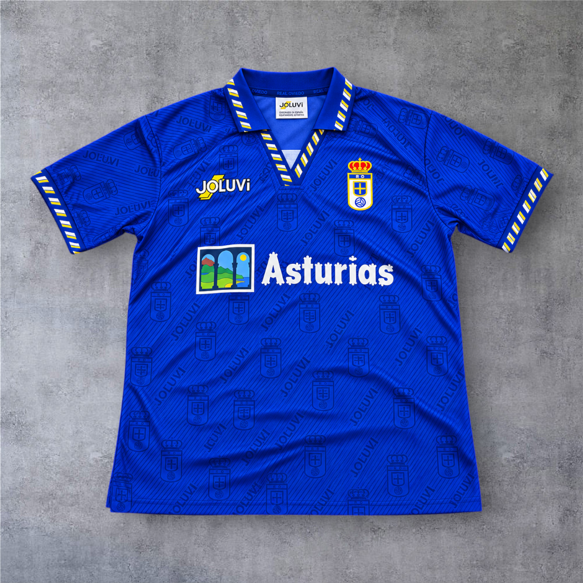 Camisola de futebol A minha loja Oviedo 1995/96 azul com padrão jacquard, gola polo e detalhes em amarelo e branco.