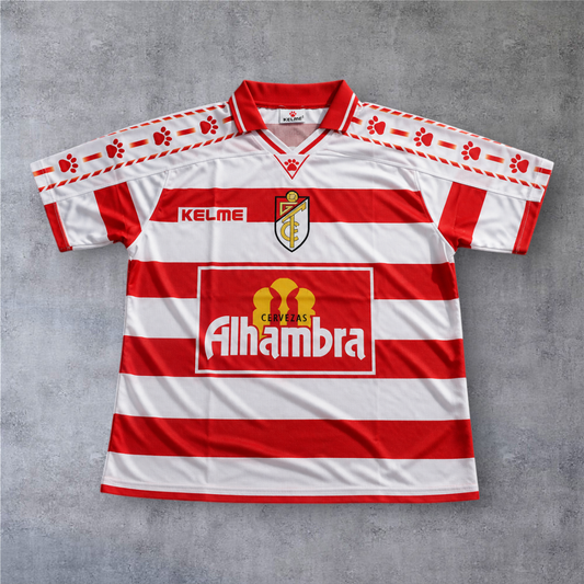 Camisola de futebol A minha loja Granada 1996/97, listada em vermelho e branco com detalhes Kelme nas mangas.