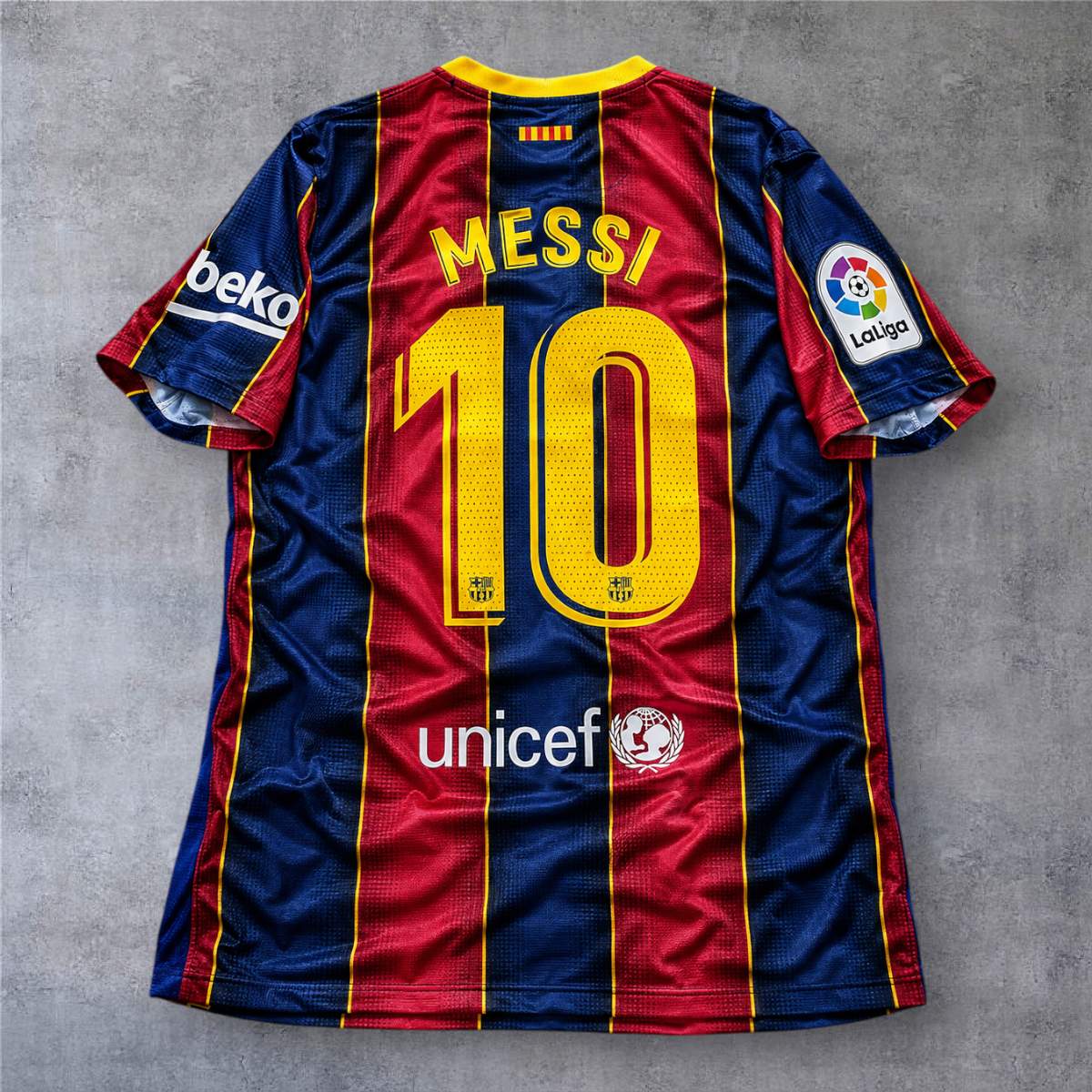 Camisola oficial A minha loja do FC Barcelona 2020/21, modelo Messi 10, com riscas verticais azuis e grenás.