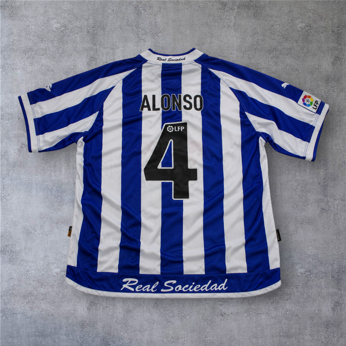 Camisola de futebol A minha loja Real Sociedad 2002/03, listada em azul e branco com nome Alonso e número 4 nas costas.