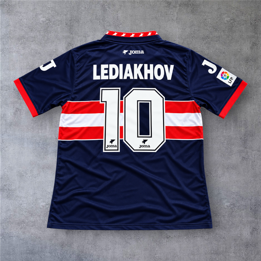 Camisola A minha loja Sporting Gijon 1996/97 Lediakhov 10, azul marinho com detalhes em vermelho e branco.