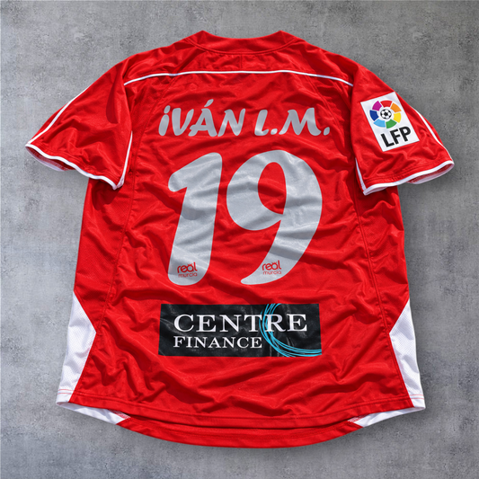 Camisola de futebol A minha loja do Real Murcia 2006/07, vermelha, com nome Ivan L.M. e número 19 nas costas.