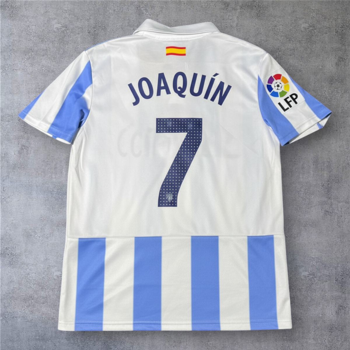 Camisola de futebol A minha loja Málaga 2012-13 branca e azul com o nome Joaquín e número 7 nas costas