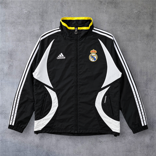 Casaco vintage Real Madrid 2006/07 preto com detalhes brancos e gola amarela, da A minha loja, estilo desportivo.