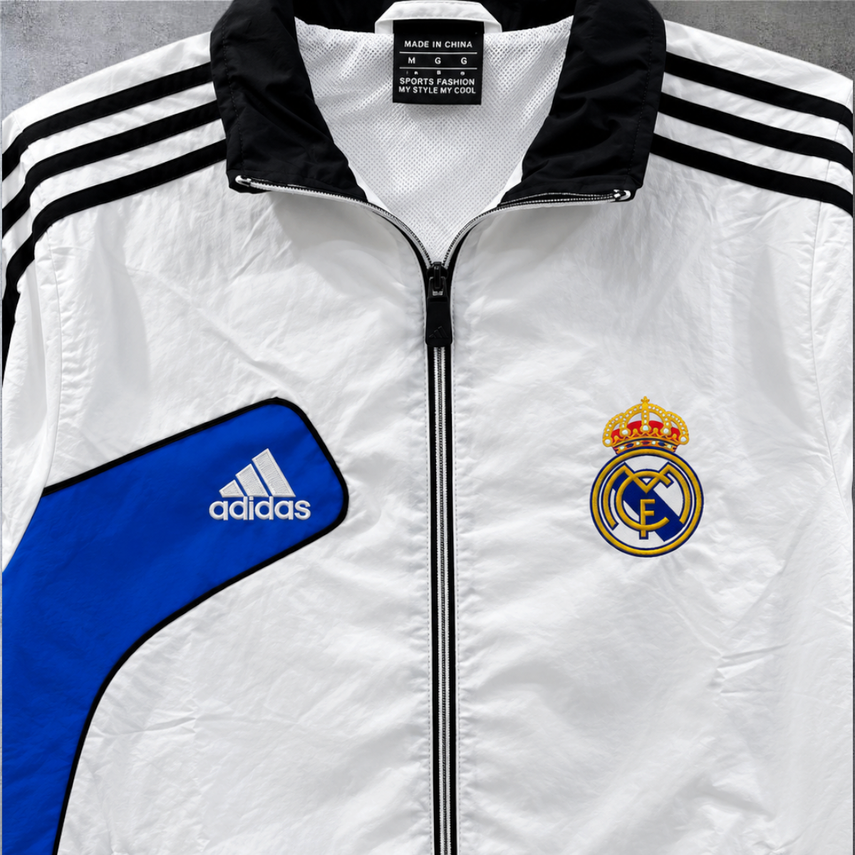 Casaco vintage Real Madrid 2012/13 A minha loja, branco com detalhes em azul e preto, fecho frontal e logótipos.