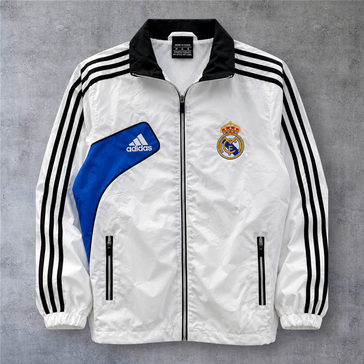 Casaco vintage Real Madrid 2012/13 branco com detalhes em azul e preto, fecho de correr e logótipo A minha loja