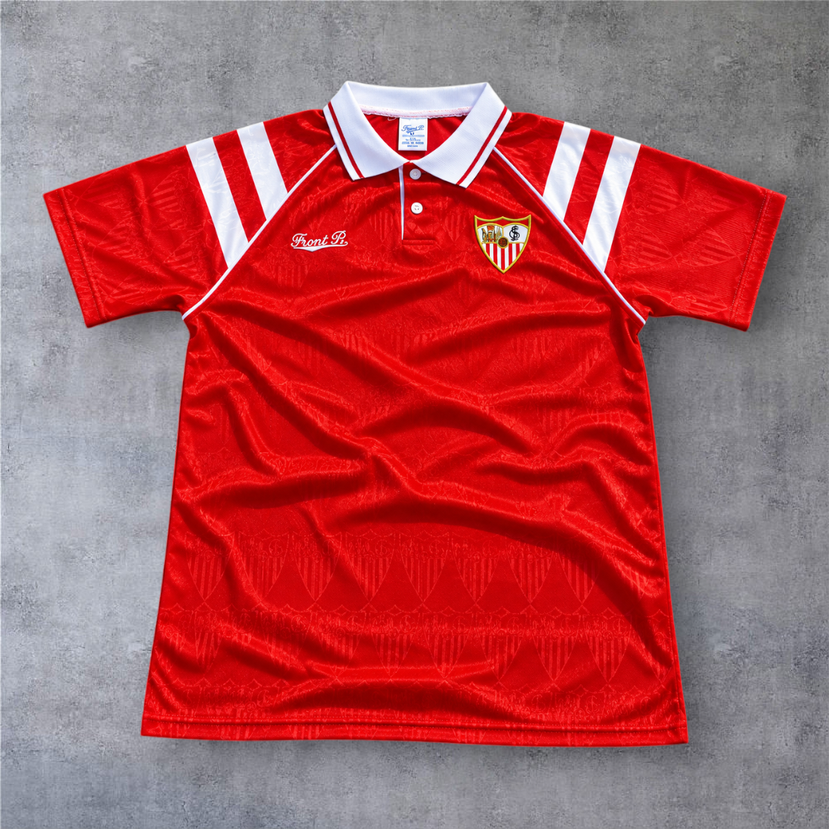 Camisola de futebol A minha loja Sevilla 1992/93 fora, vermelha com gola polo branca e detalhes clássicos.