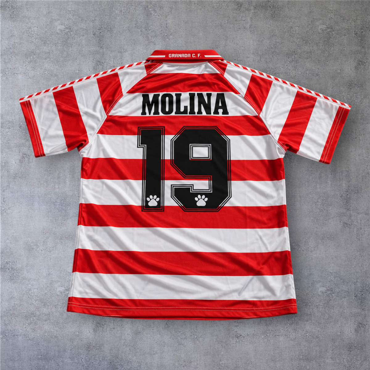 Camisola de futebol A minha loja Granada 1996/97 do Molina, com riscas horizontais vermelhas e brancas.