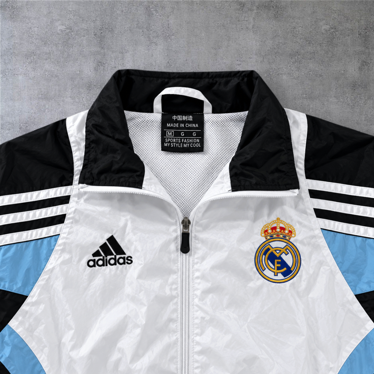 Casaco vintage Real Madrid 2003/04 A minha loja, branco, preto e azul claro com fecho frontal e logótipo bordado.