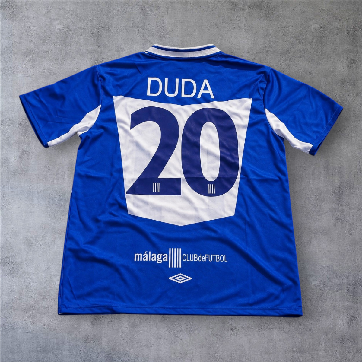 Camisola de futebol A minha loja Malaga 2005/06, azul com o nome Duda e o número 20 nas costas, tecido respirável.