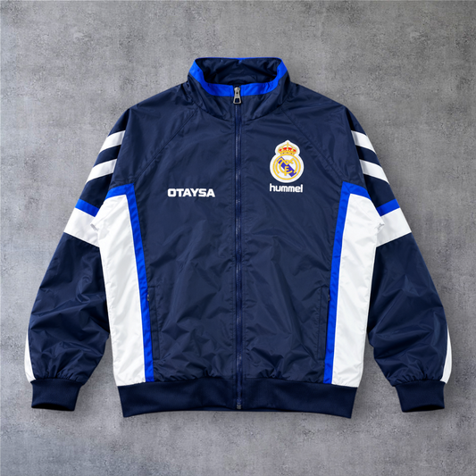 Casaco vintage Real Madrid 1991 da A minha loja, azul marinho com detalhes brancos e azuis, fecho completo e emblema.