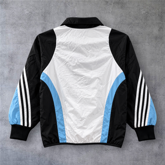 Casaco vintage Real Madrid 2003/04 da A minha loja, com design tricolor em branco, preto e azul e fecho frontal.