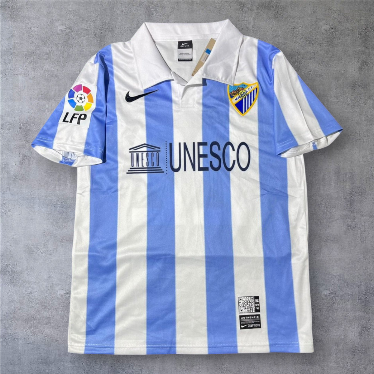 Camisola de futebol A minha loja Málaga 2012-13 oficial com riscas verticais azuis e brancas e gola clássica