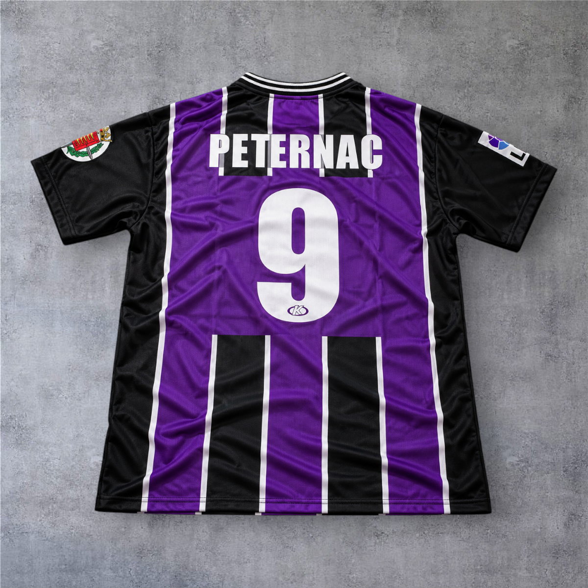 Camisola de futebol A minha loja do Valladolid 1999/00, roxa e preta, com o nome Peternac e número 9 nas costas.