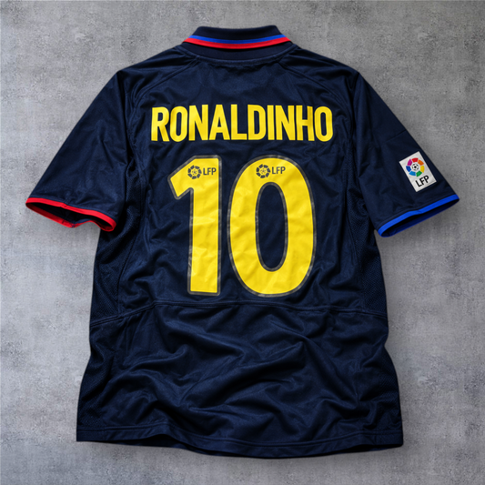 Camisola de futebol A minha loja do Barcelona 2002/03, azul-marinho com o nome Ronaldinho e número 10 em amarelo.
