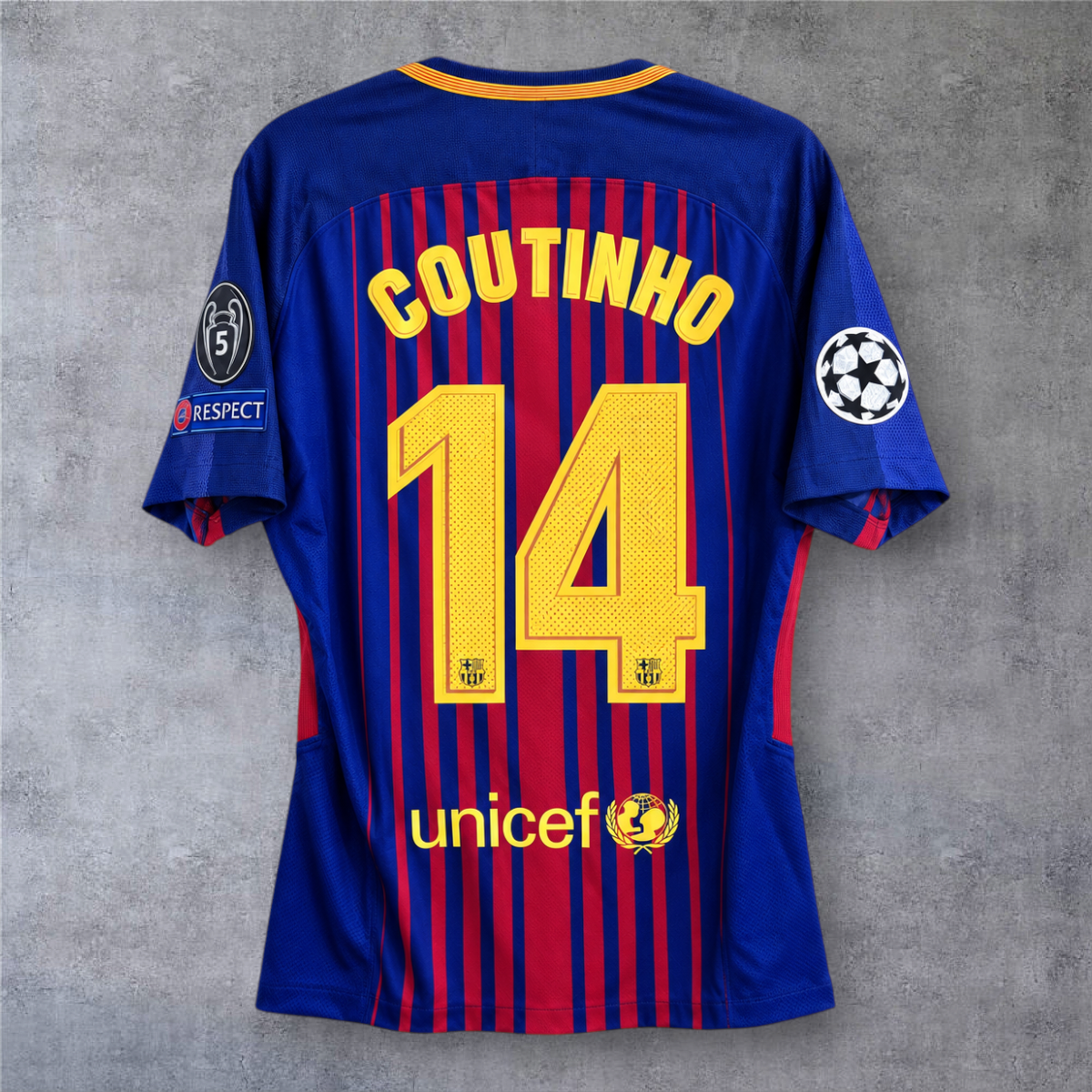 Camisola A minha loja do Barcelona 2017/18, modelo Coutinho 14, azul e grená com emblemas da Champions League.