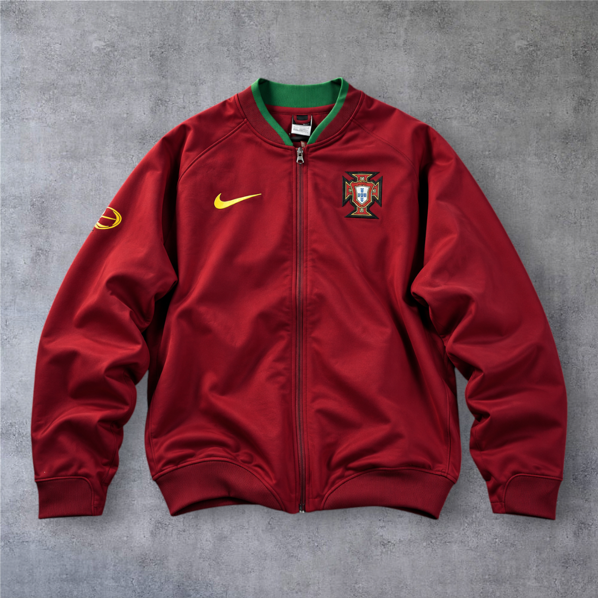 Casaco vintage de Portugal 2006 da A minha loja, vermelho com detalhes verdes, fecho completo e emblema da seleção.