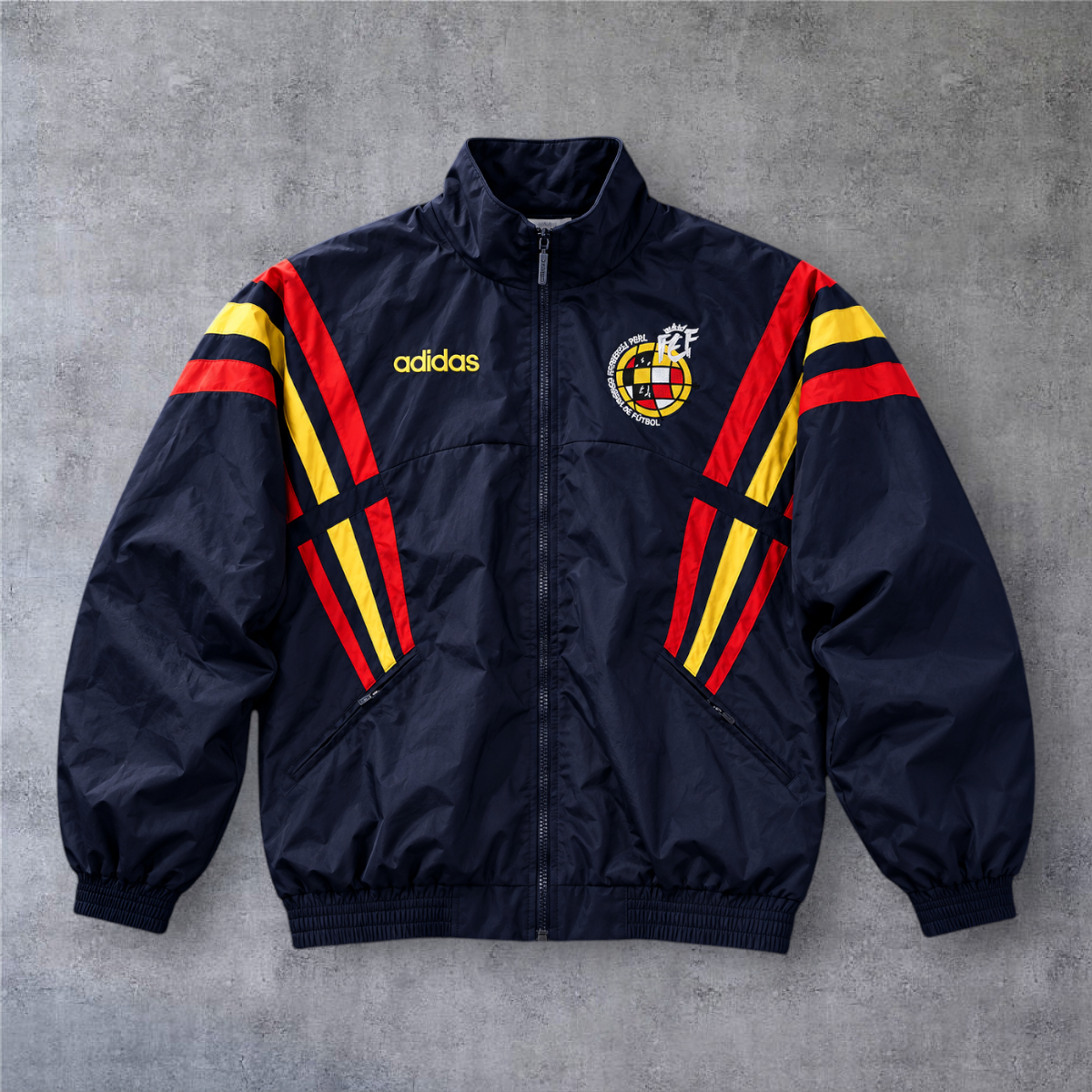 Casaco vintage da Espanha 1996 A minha loja, azul-marinho com detalhes em amarelo e vermelho e fecho de correr.