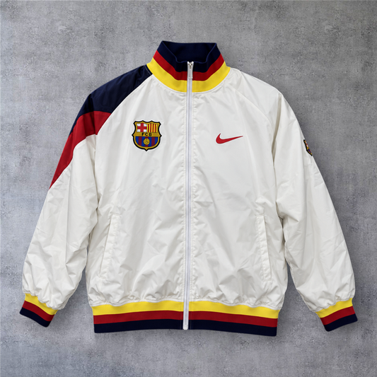 Casaco vintage A minha loja do Barcelona 1995, branco com detalhes em azul, vermelho e amarelo e fecho frontal.