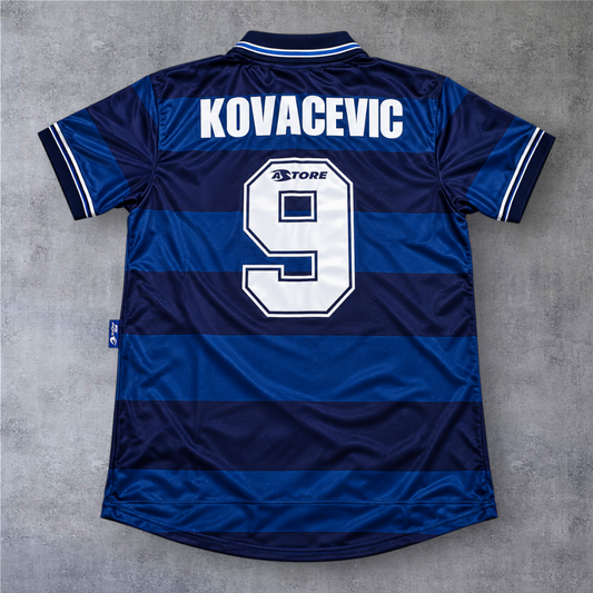 Camisola de futebol A minha loja Real Sociedad 1998/99 fora, azul com riscas, nome Kovacevic e número 9 nas costas.