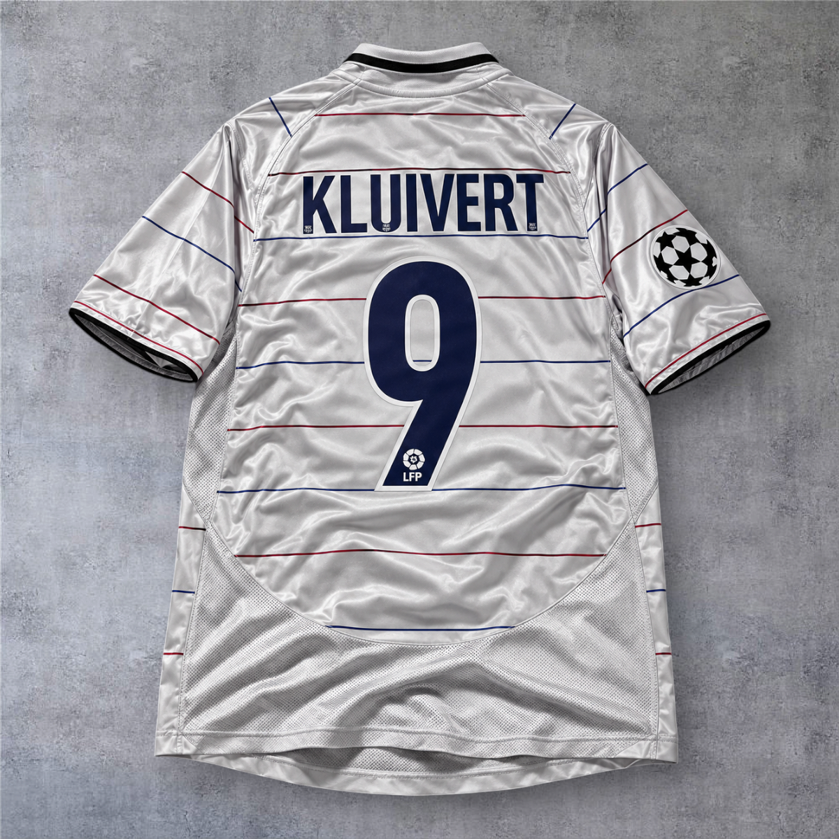 Camisola de futebol A minha loja do Barcelona 2003/04, branca com riscas, nome Kluivert e número 9 nas costas.