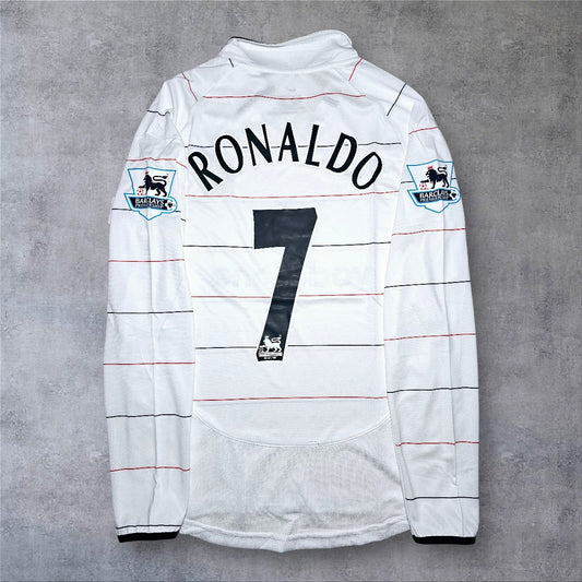 A minha loja camisola de futebol branca de manga comprida do Manchester United 2003/04 com o nome Ronaldo e o número 7 nas costas.